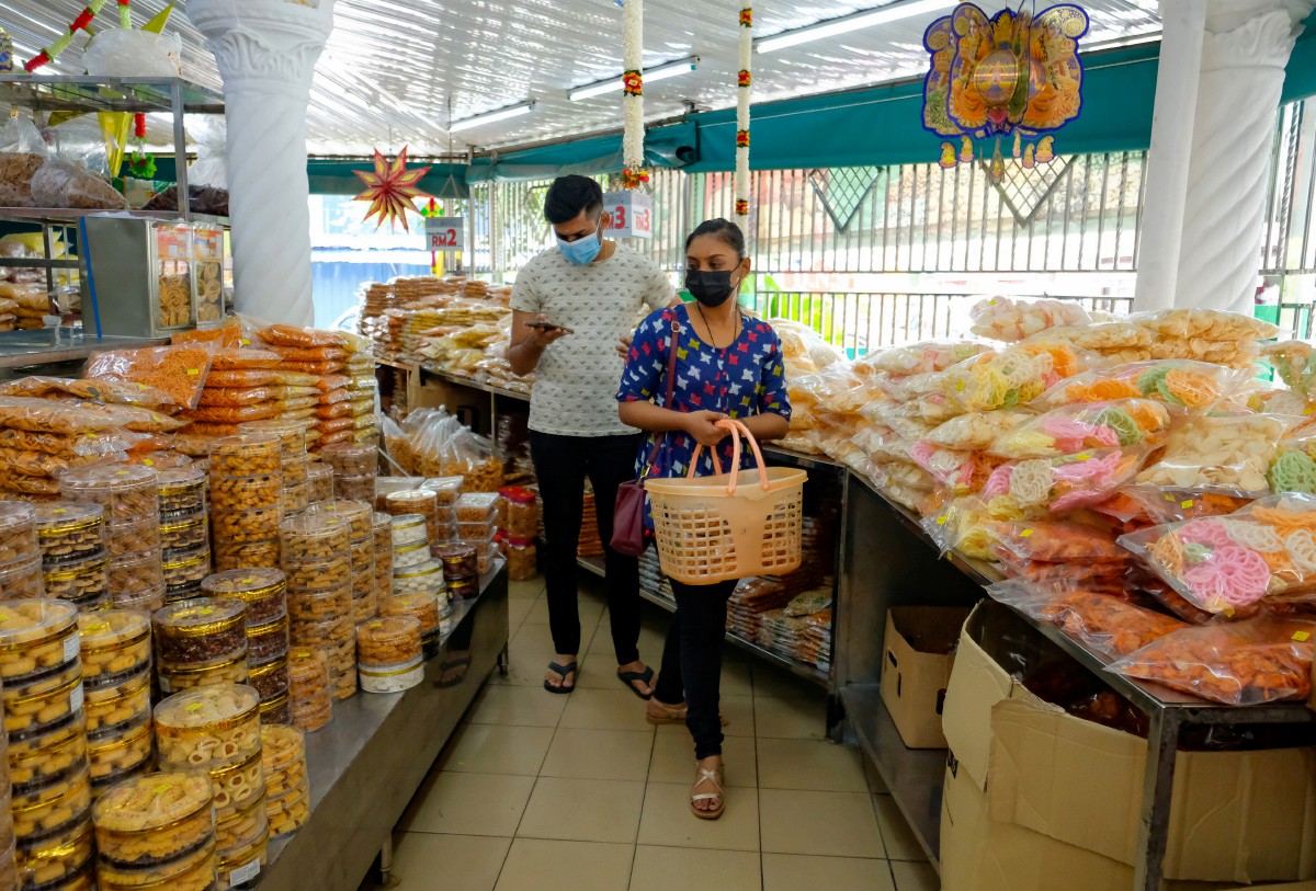 PENGUNJUNG memgambil peluang untuk membeli pelbagai jenis kekacang dan kerepek di Kampung Kacang Puteh sempena persiapan menyambut Deepavali. FOTO Bernama