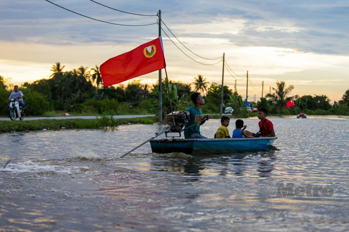 PENDUDUK kampung menggunakan bot meninjau keadaan sawah yang dinaiki air di Kampung Kandai, Mukim Tajar akibat limpahan sungai Kedah, 4 November lalu. FOTO Luqman Hakim Zubir