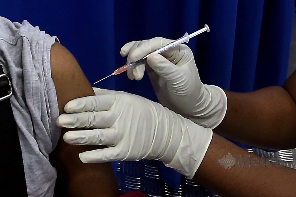 PETUGAS kesihatan memberi suntikan vaksin Covid-19 di Georgetown, semalam. FOTO Danial Saad