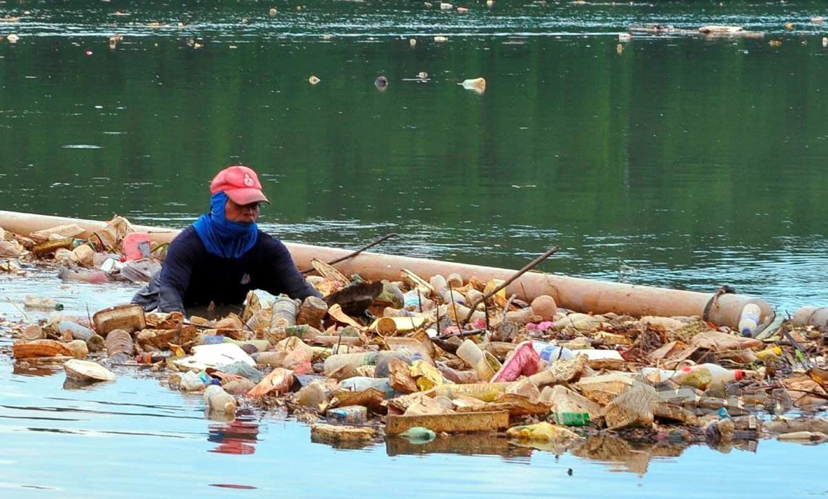 HAMID membersihkan sampah di sekitar Sungai Tebrau, berhampiran Kampung Bakar Batu, Johor Bahru. FOTO Nurul Amanina Suhaini
