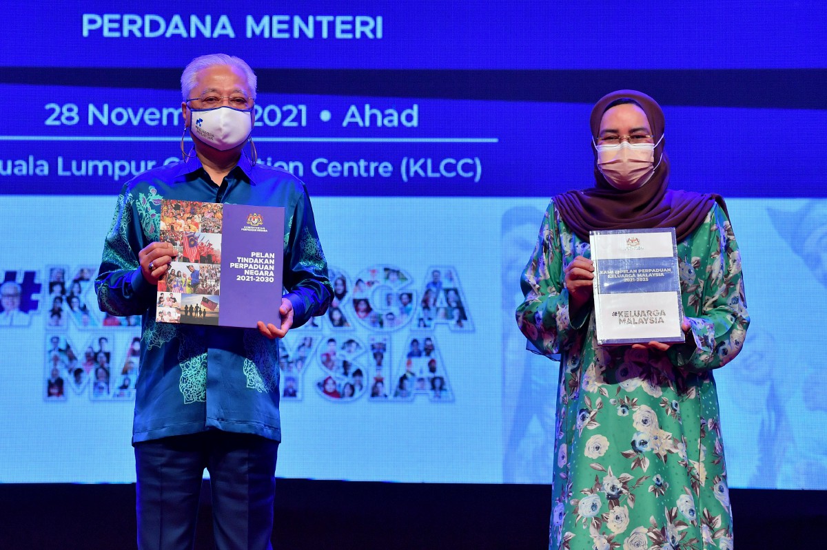 ISMAIL Sabri (kiri) dan Halimah menunjukkan buku Pelan Tindakan Perpaduan Negara 2021-2030 dan Kami @ Pelan Perpaduan Keluarga Malaysia 2021-2025. FOTO Bernama