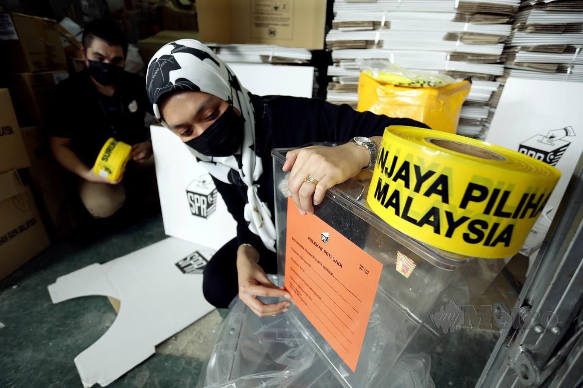 PETUGAS SPR Sarawak,Nadiah Salim dan Affiq Aiman Asuandi meyusun kit peralatan mengundi  di Kuching, kelmarin, untuk diagihkan ke pusat mengundi di Sarawak. FOTO Nadim Bokhari