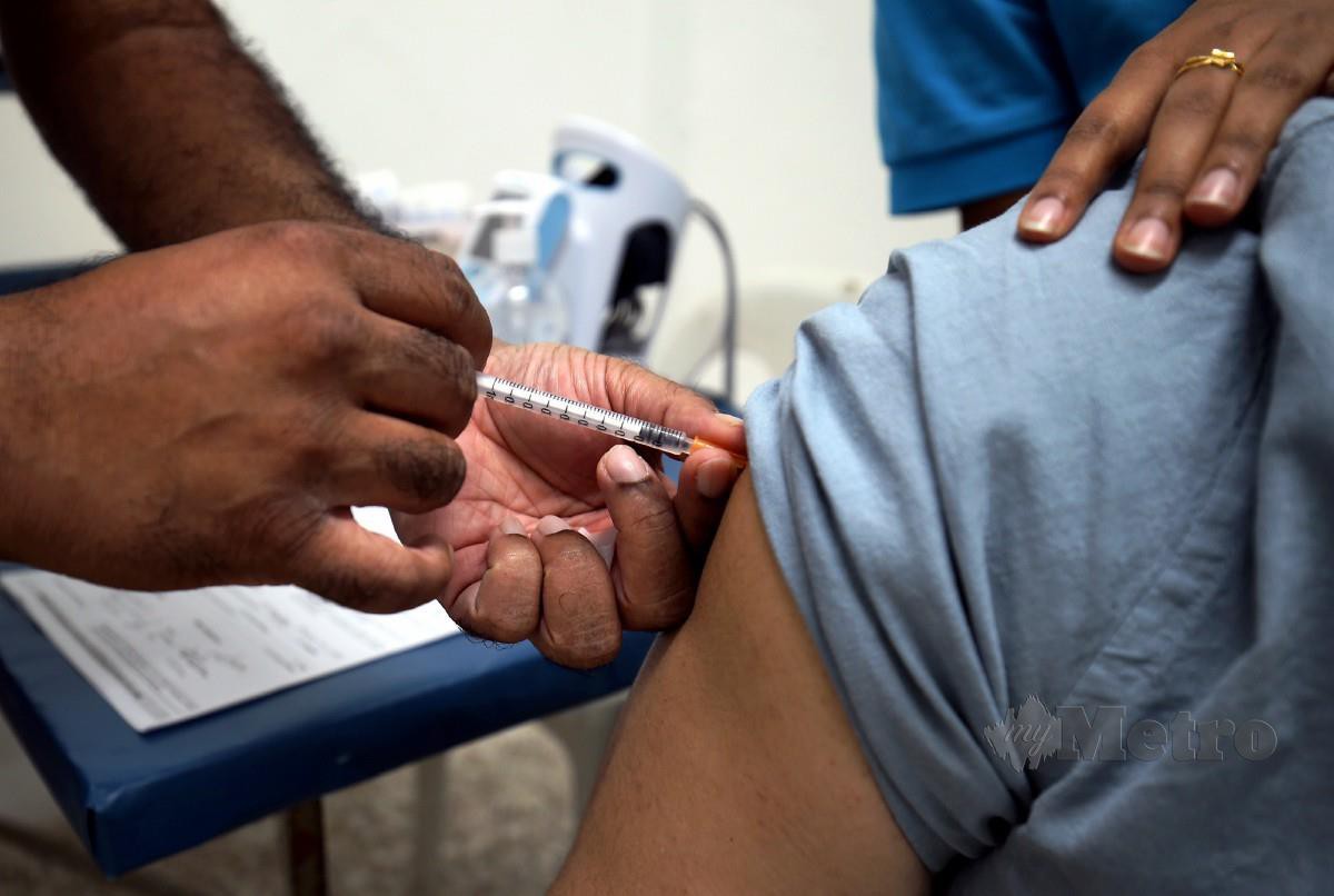 DOKTOR memberikan suntikan dos penggalak vaksin Coivd-19 kepada penerima di klinik di Georgetown, semalam FOTO Mikail Ong