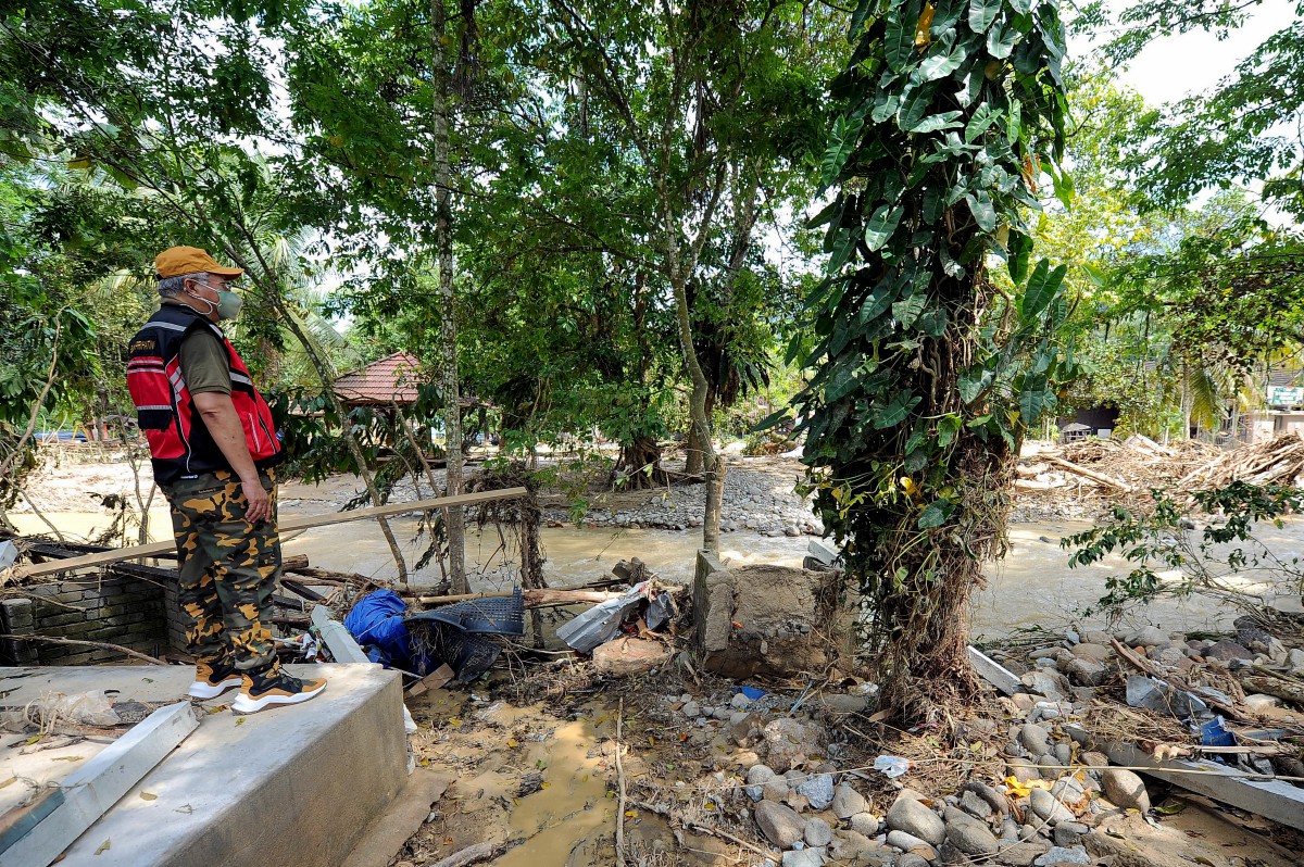 ANNUAR Musa meninjau  kerosakan yang berlaku akibat banjir di Kampung Pulau Santap Janda Baik. FOTO Bernama