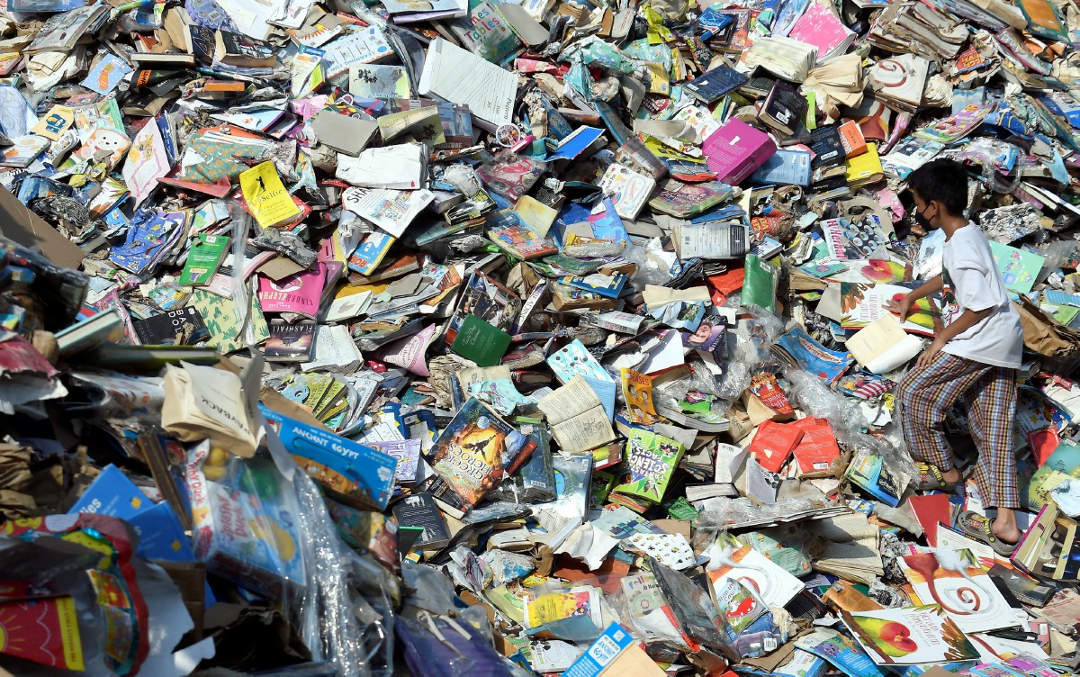 KANAK-KANAK mencari buku yang masih boleh digunakan dari longgokan kira-kira 2 juta buku yang rosak kesan daripada banjir minggu lalu ketika tinjauan di gudang buku The Big Wolf Seksyen 33 Shah Alam, semalam. FOTO Bernama