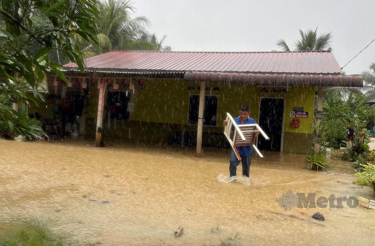 PENDUDUK, Yuzaini Yahya, 48, mengalihkan perabot rumah apabila rumahnya dinaiki air di Kampung Spang Loi Segamat, Johor. FOTO Nur Aisyah Mazalan