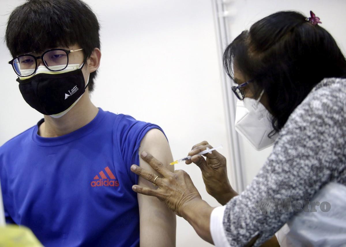 PETUGAS perubatan memberikan suntikan dos penggalak vaksin Covid-19 kepada penerima di Seberang Jaya, semalam. FOTO Danial Saad