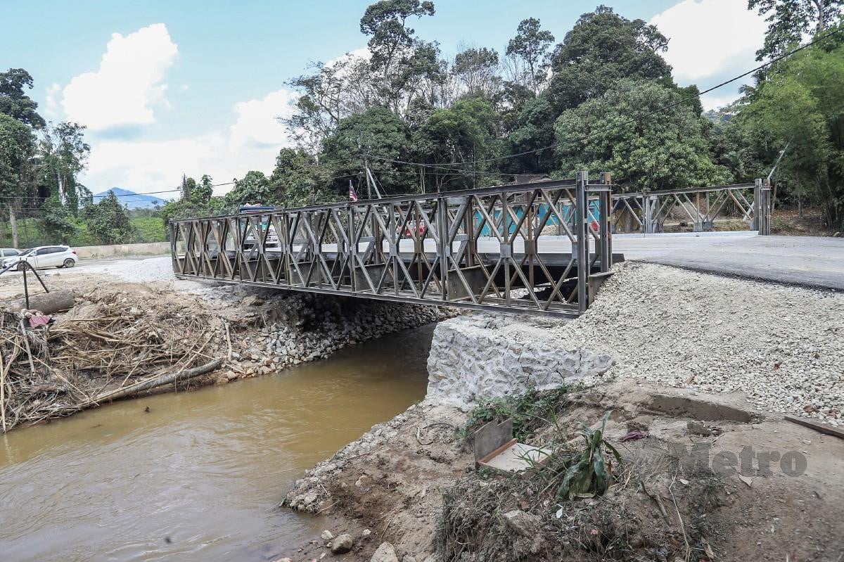 PENDUDUK Kampung Jawa mengunakan jambatan sementara yang dipasang Angkatan Tentera Malaysia dan JKR Petaling dan Hulu Langat yang kini menjadi laluan hubungan penduduk kampung jawa susulan kerosakan jambatan lama oleh banjir besar. FOTO Owee Ah Chun
