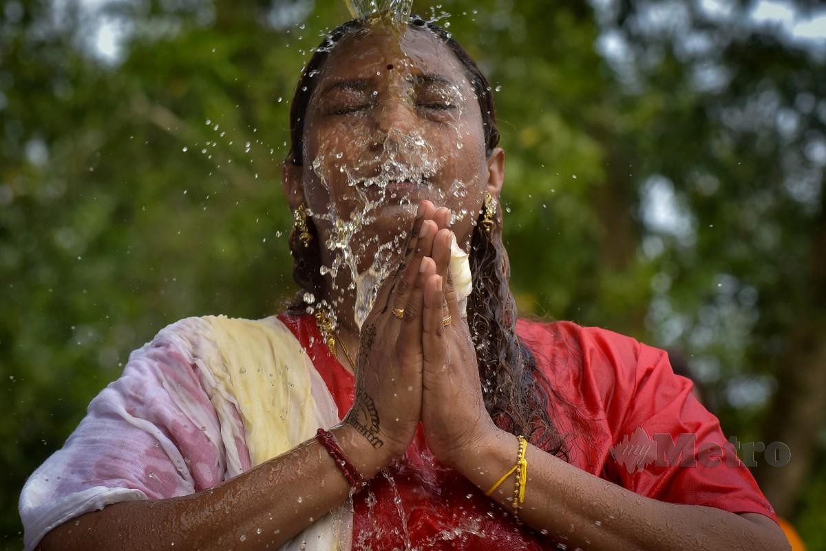 Penganut Hindu dilihat menyucikan badan sebelum membawa belanga berisi susu ke Kuil Thirumurugan Labuan. FOTO Bernama