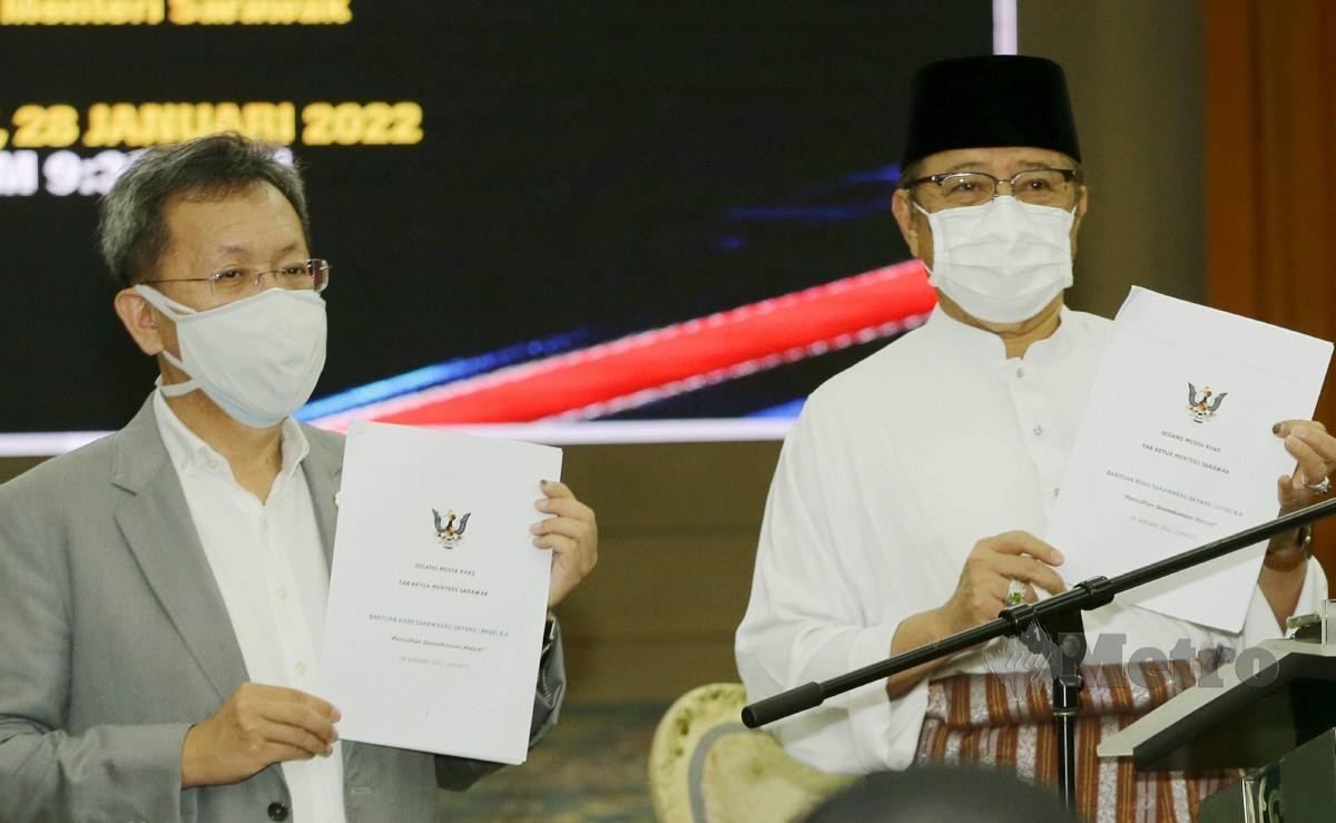 ABANG Johari (kanan) menunjukan dokumen Bantuan Khas Sarawakku Sayang. FOTO Nadim Bokhari
