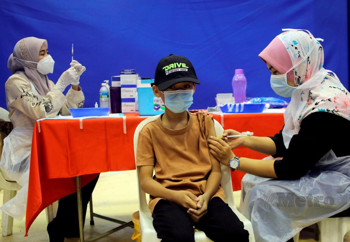 PEGAWAI kesihatan melakukan suntikan vaksin Covid-19 kepada kanak-kanak di Kuala Terengganu, semalam. FOTO Ghazali Kori