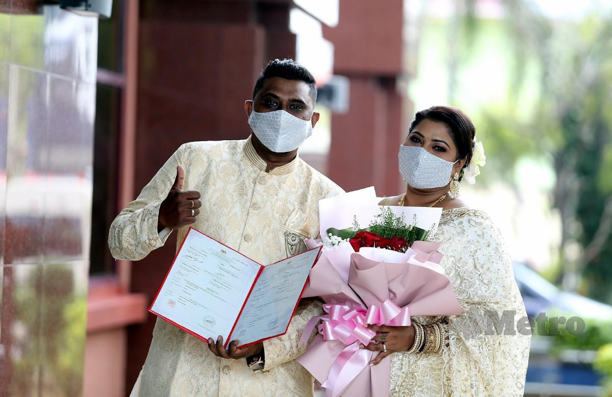 A Santhanasamy, 32, (kiri) bersama isterinya Ambika, 32, bergambar selepas selesai mendaftar perkahwinan di Georgetown. FOTO Mikail Ong