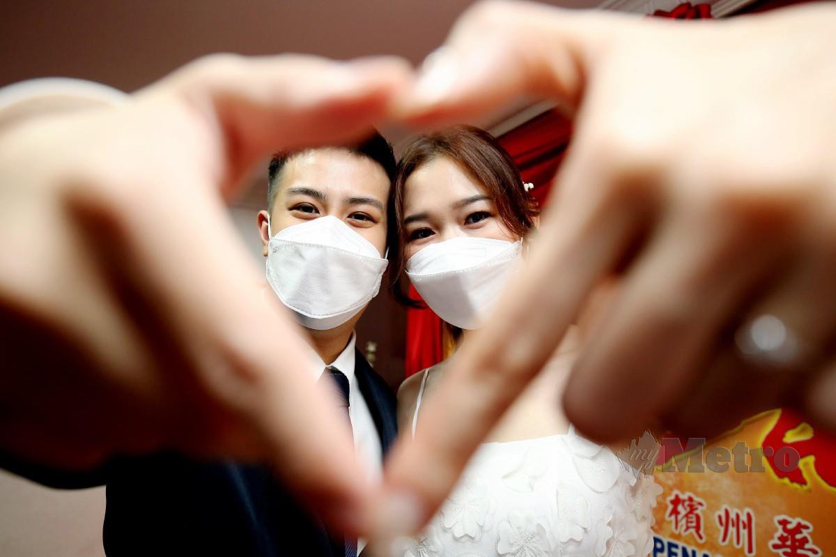 Tan ZheYan, 28, (kiri) dan Lau Ko Ee, 28, bergambar kenangan selepas selesai mendaftar perkahwinan di Georgetown. FOTO Mikail Ong