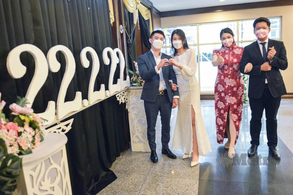 Pasangan pengantin bergambar selepas mendaftar perkahwinan di Jabatan Pendaftaran Negara, Putrajaya. Seramai 60 pasangan pengantin bukan Islam mendaftar perkahwinan mereka sempena tarikh istimewa 22 Februari 2022. FOTO Aizuddin Saad