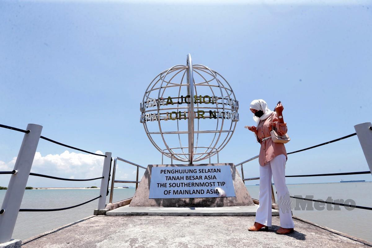 Fatin Humairah Mohd Sabri mengambil gambar bayangnya yang kelihatan mengecil pada 1.15 tengah hari 24 Mac 2022 di Tanjung Piai, Pontia, iaitu titik paling selatan benua Asia. FOTO  NUR AISYAH MAZALAN