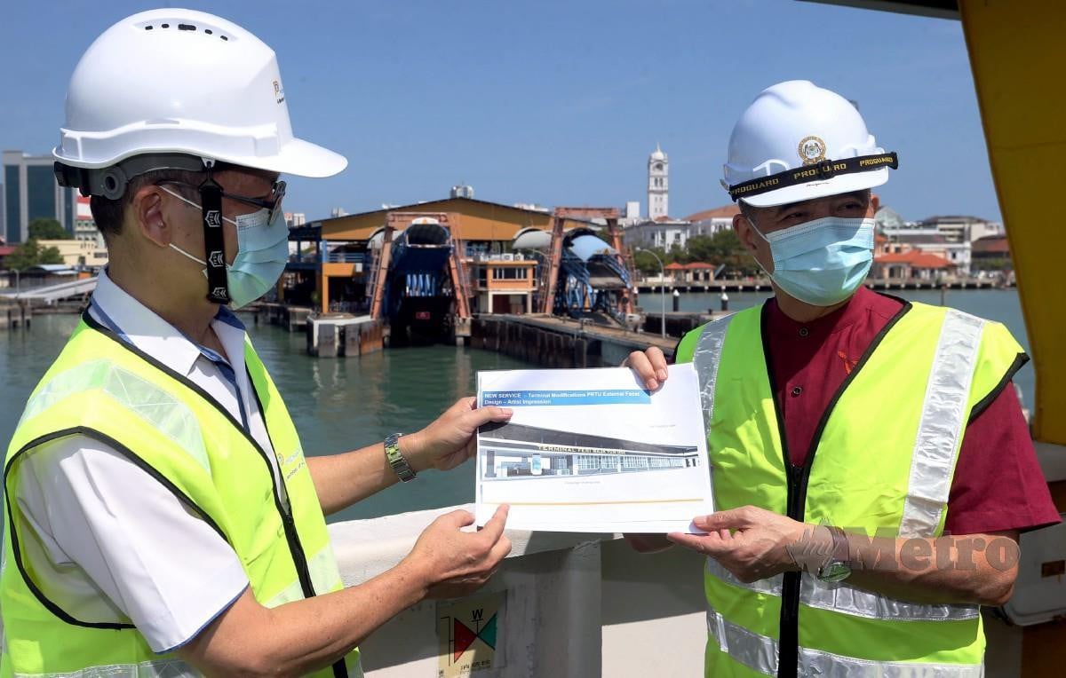 TAN Teik Cheing (kanan) bersama Ketua Perkhidmatan Feri Penang Port Sdn Bhd (PPSB) Ang Hooi Wong menunjukkan plan projek terminal feri Pangkalan Raja Tun Uda (PRTU) selepas meninjau kerja naik taraf terminal feri. FOTO Danial Saad