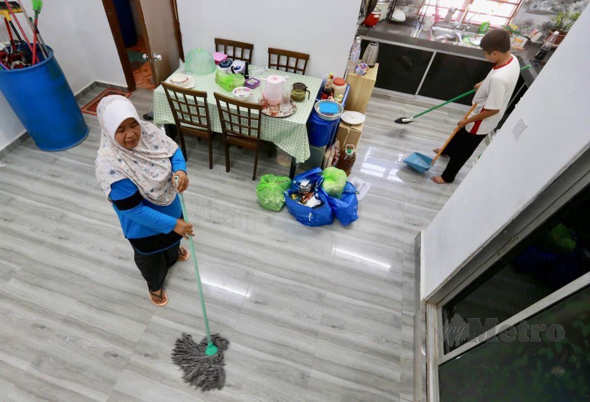 MANGSA banjir Normadiah Mohd Bakri, 49, mengemas rumahnya di Kampung Sungai Lui. Rumahnya terjejas akibat banjir Disember lalu. FOTO Fathil Asri