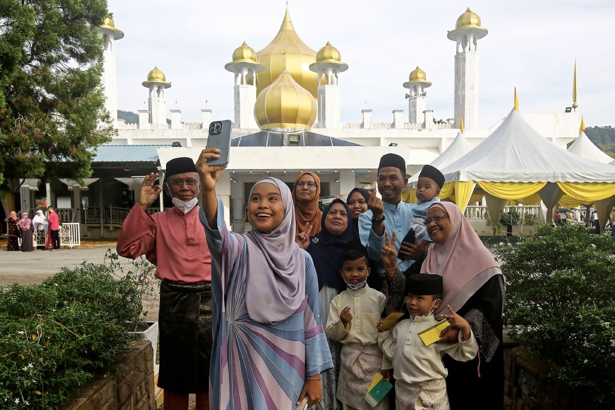 Sebuah keluarga dilihat merakam gambar kenangan selepas menunaikan solat sunat Aidiladha di Masjid Diraja Tuanku Munawir, Kuala Pilah. FOTO Bernama