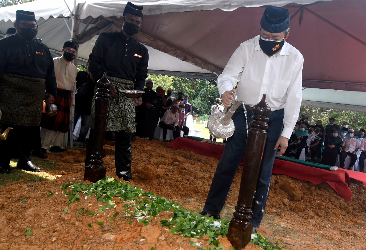 SULTAN Sharafuddin  berkenan menyiram air mawar selepas pengkebumian jenazah Abdul Khalid di Makam DiRaja Shah Alam. FOTO Bernama