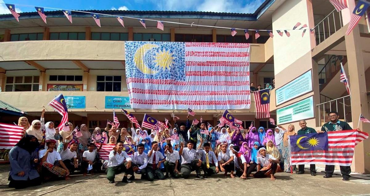 GURU dan pelajar SMK Manek Urai menzahirkan semangat patriotik dengan cara tersendiri apabila mencipta Jalur Gemilang menggunakan cap tangan. FOTO Hazira Ahmad Zaidi