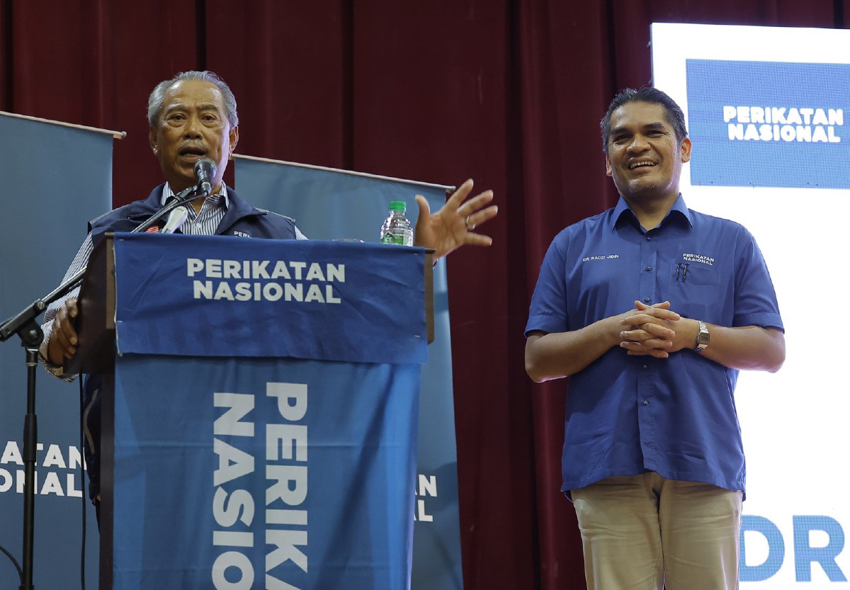 MUHYIDDIN Yassin (kiri) mengumumkan Calon Perikatan Nasional Parlimen Putrajaya, Datuk Dr Radzi Jidin pada Program Jelajah Prihatin Parlimen Putrajaya malam ini. FOTO Bernama --