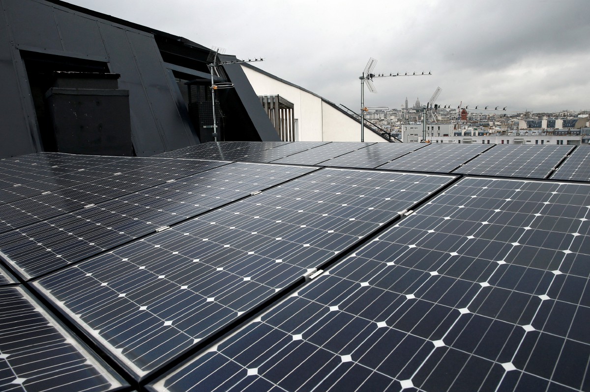 Pemasangan panel solar pada bumbung bangunan di Paris. FOTO Reuters.