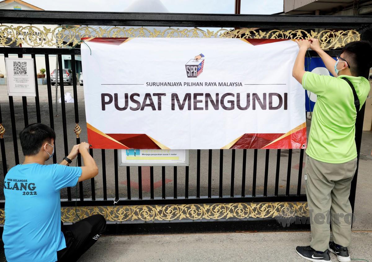 Petugas SPR menggantung poster bagi persiapan akhir untuk proses pengundian sempena PRU-15) di Pusat Mengundi bagi kawasan Parlimen Klang di SJKC Pandamaran B. FOTO BERNAMA