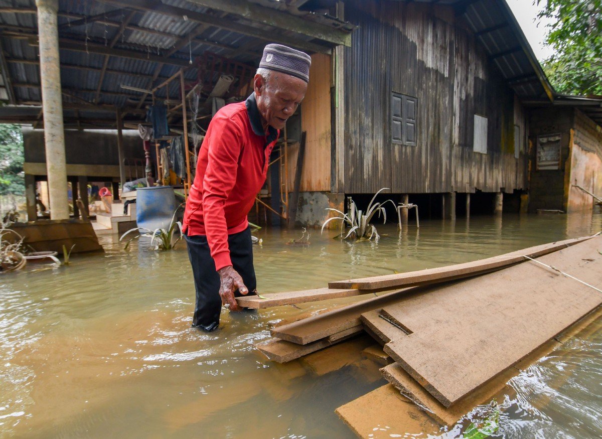 PAPAN yang akan digunakan untuk membaiki rumah Che Ali turut tenggelam susulan banjir. FOTO Bernama