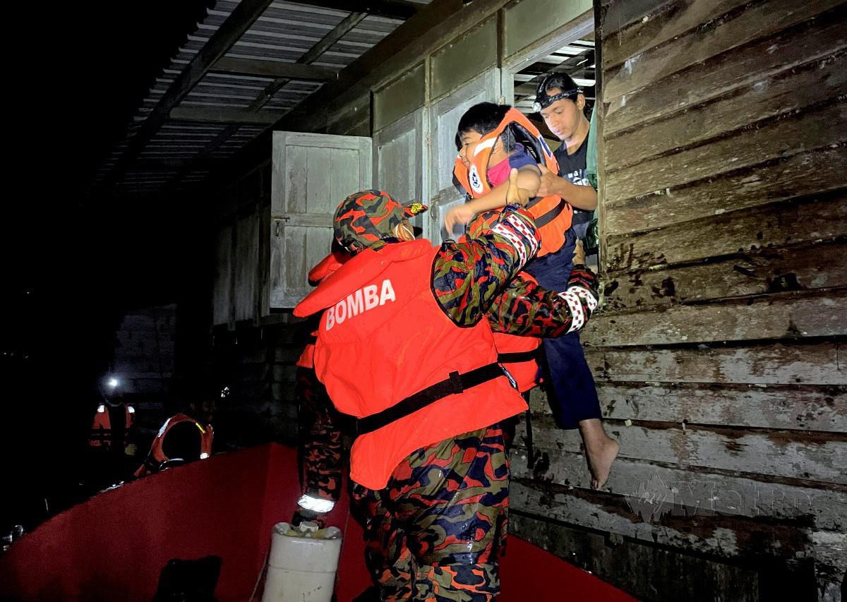 Anggota Bomba dan Penyelamat (JPBM) menyelamatkan penduduk yang terperangkap dalam banjir selepas rumah mereka dinaiki air di Kampung Paya Besar, Kuala Berang pada 28 Februari. FOTO GHAZALI KORI 