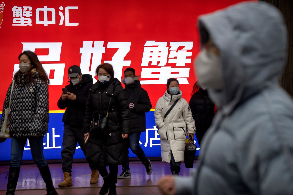 PENUMPANG memakai pelitup muka di stesen kereta api bawah tanah di Beijing. FOTO AP