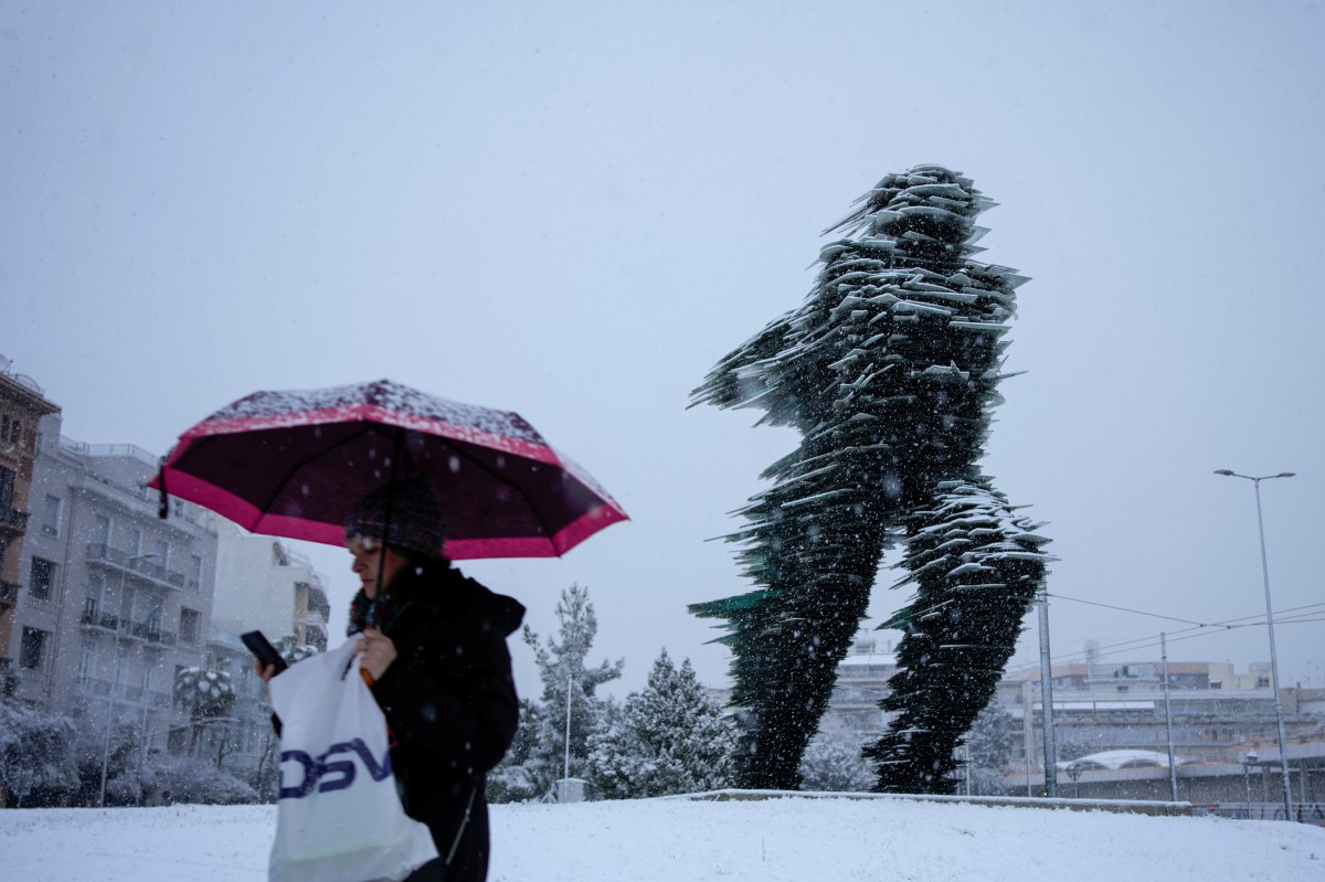Penduduk berjalan berhampiran arca dinamakan Runner, hasil seni Kostas Varotsos di Athens. FOTO AP