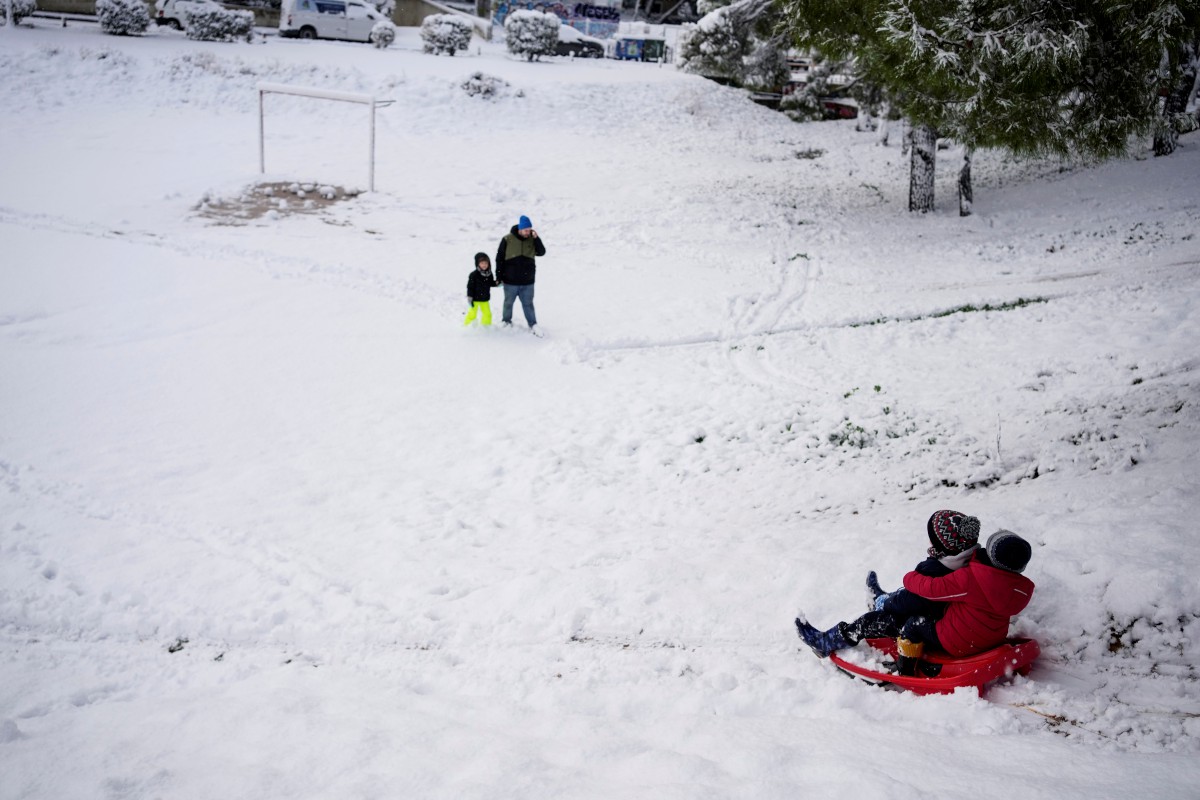 Kanak-kanak bermain salji di Vrilisia, Athens. FOTO AP