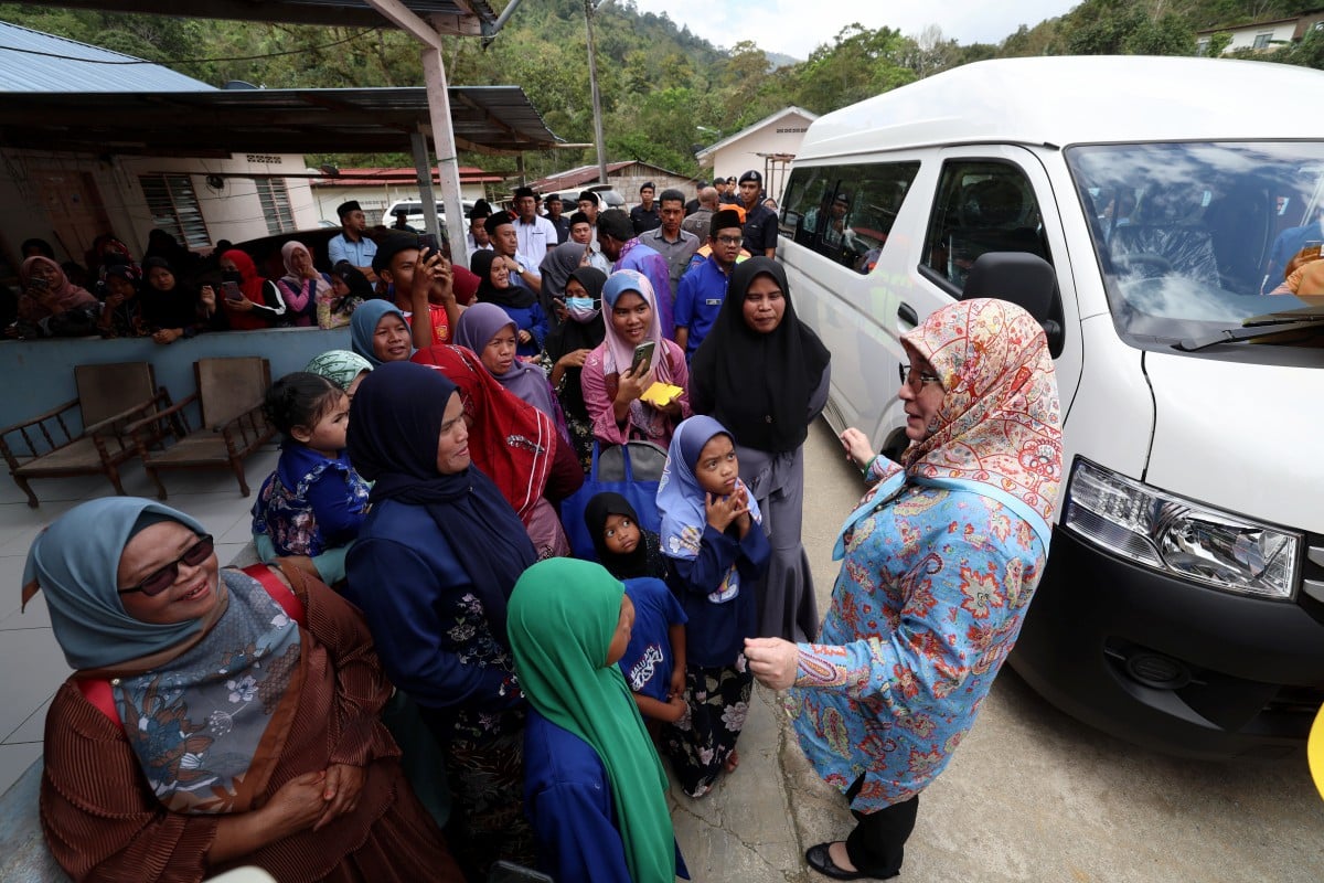 TUNKU Azizah berkenan beramah mesra bersama penduduk ketika menghadiri lawatan ke Kampung Orang Asli Kuala Boh. FOTO Bernama