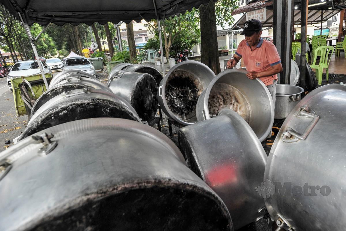 Pekerja Bubur Lambuk Hj Razali, Enton Ngatmin, 52, membersihkan periuk yang akan digunakan untuk memasak bubur lambuk dan dijual kepada orang ramai dengan harga RM3 sempena Ramadan ketika tinjauan di Kampung Baru, Kuala Lumpur. FOTO Aizuddin Saad