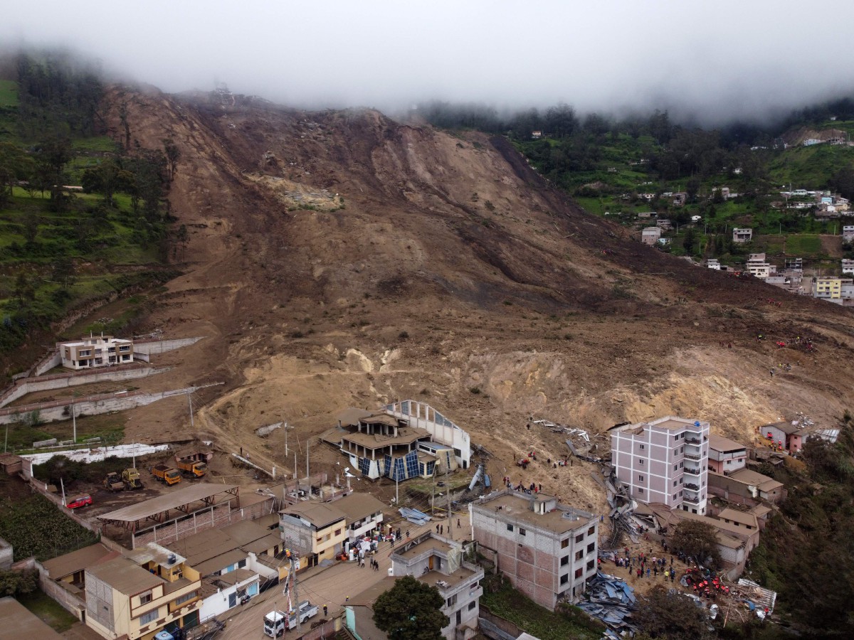 TOPSHOT - Aerial view following a landslide in Alausi, Ecuador on March 27, 2023. - At least 7 people have died, and 46 other are still missing after a landslide in the south of Ecuador caused by months of heavy rainfall, the government said. (Photo by Marcos PIN / AFP)