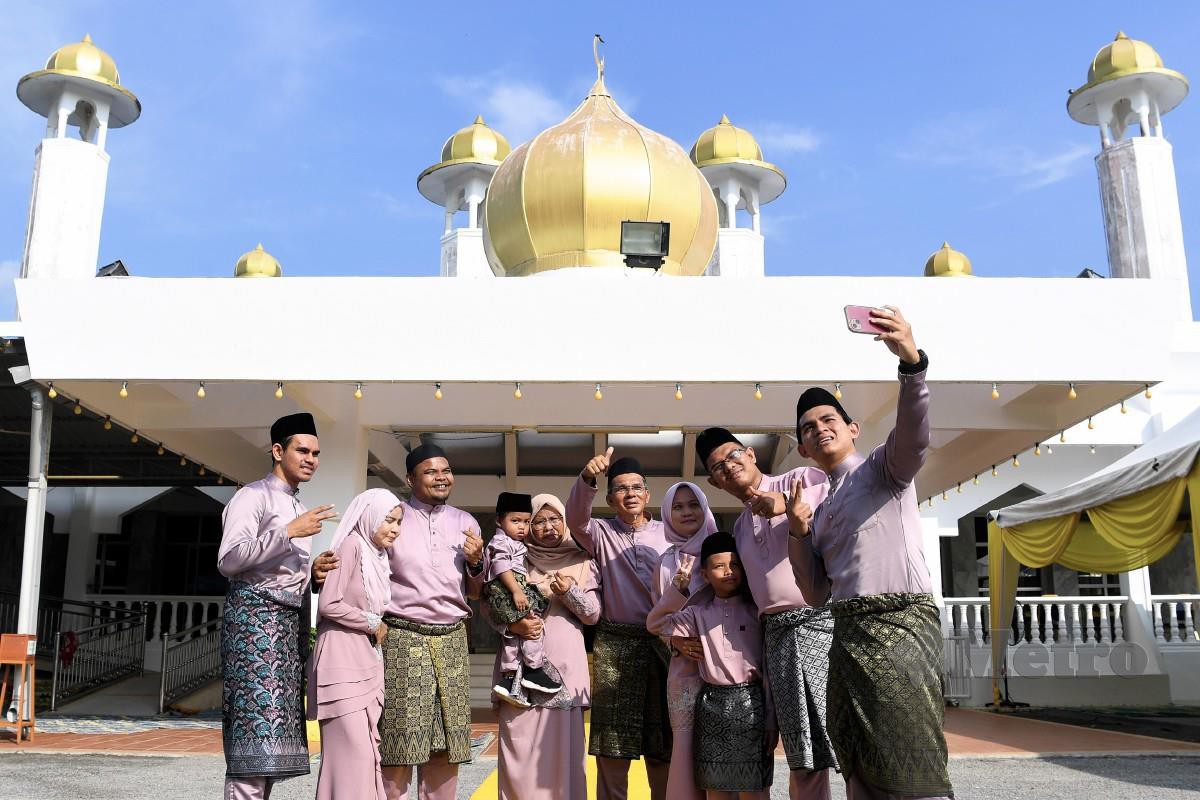 Keluarga Nawawi Jantan dari Kuantan dilihat merakam gambar kenangan selepas menunaikan solat sunat Aidilfitri di Masjid Diraja Tuanku Munawir, Kuala Pilah. FOTO Bernama