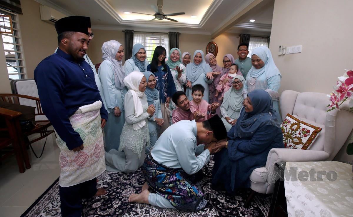 Ku Mashariman Ku Mahmood  bersama sanak saudara bersalaman dengan ibu, Zainab Nordin, 73, (kanan) pada sambutan Aidilfitri di Kampung Melayu Ampang, Selangor. FOTO Hairul Anuar Rahim