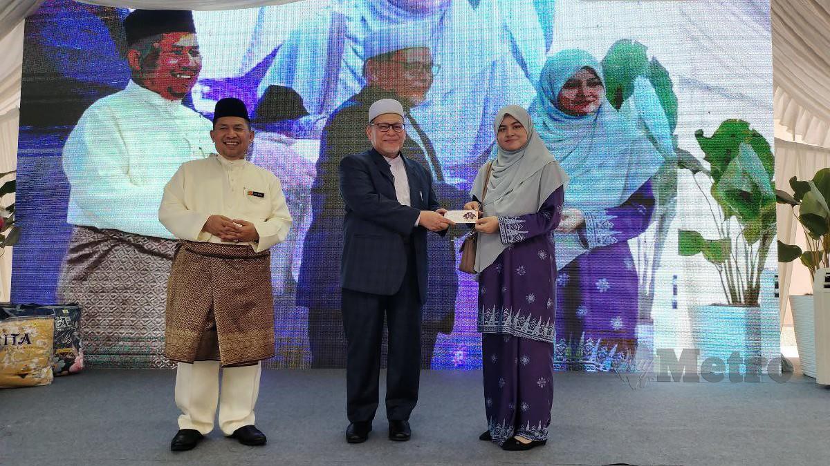 MOHD Amar (tengah) menyampaikan sumbangan duit raya di Majlis Jalinan Kasih Aidilfitri Kumpulan PKINK 2023. FOTO Syaherah Mustafa