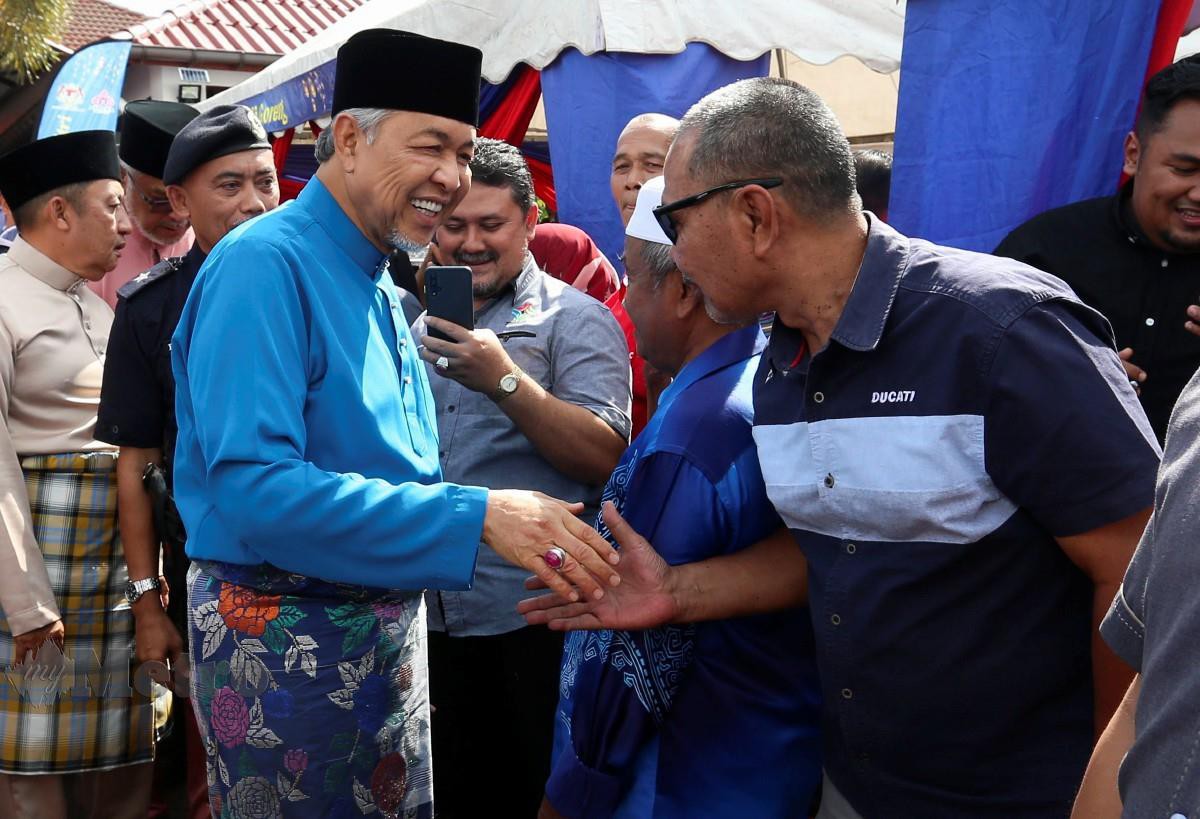 AHMAD Zahid bersalaman dengan orang ramai di Majlis Sambutan Aidilfitri Felcra Bhd di Machang. Turut hadir Ahmad Jazlan (kiri). FOTO Nik Abdullah Nik Omar