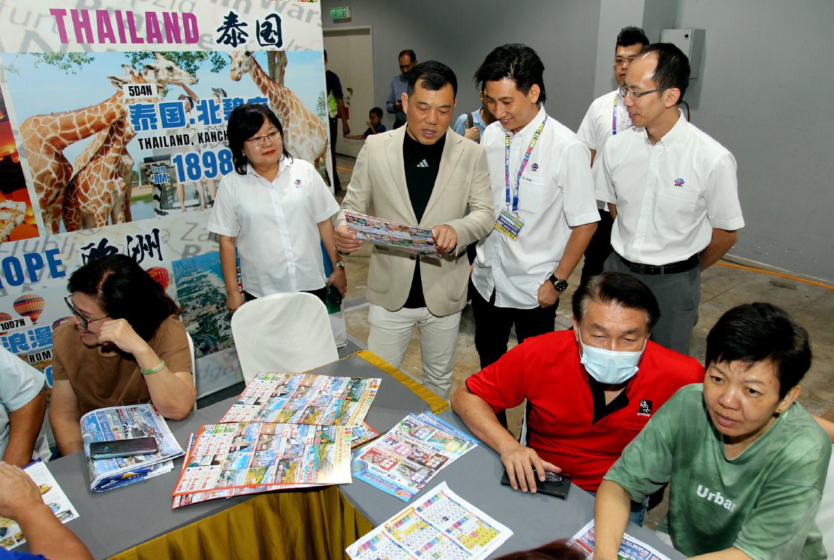 LOH Sze Yee (berdiri tiga, kanan) melawat reruai pameran selepas merasmikan Pameran Persatuan Ejen Pelancongan dan Pengembaraan Malaysia (MATTA Fair) Perak. Turut hadir, Pengerusi Penganjur MATTA Perak Wendy Shin (berdiri, kiri). FOTO Bernama