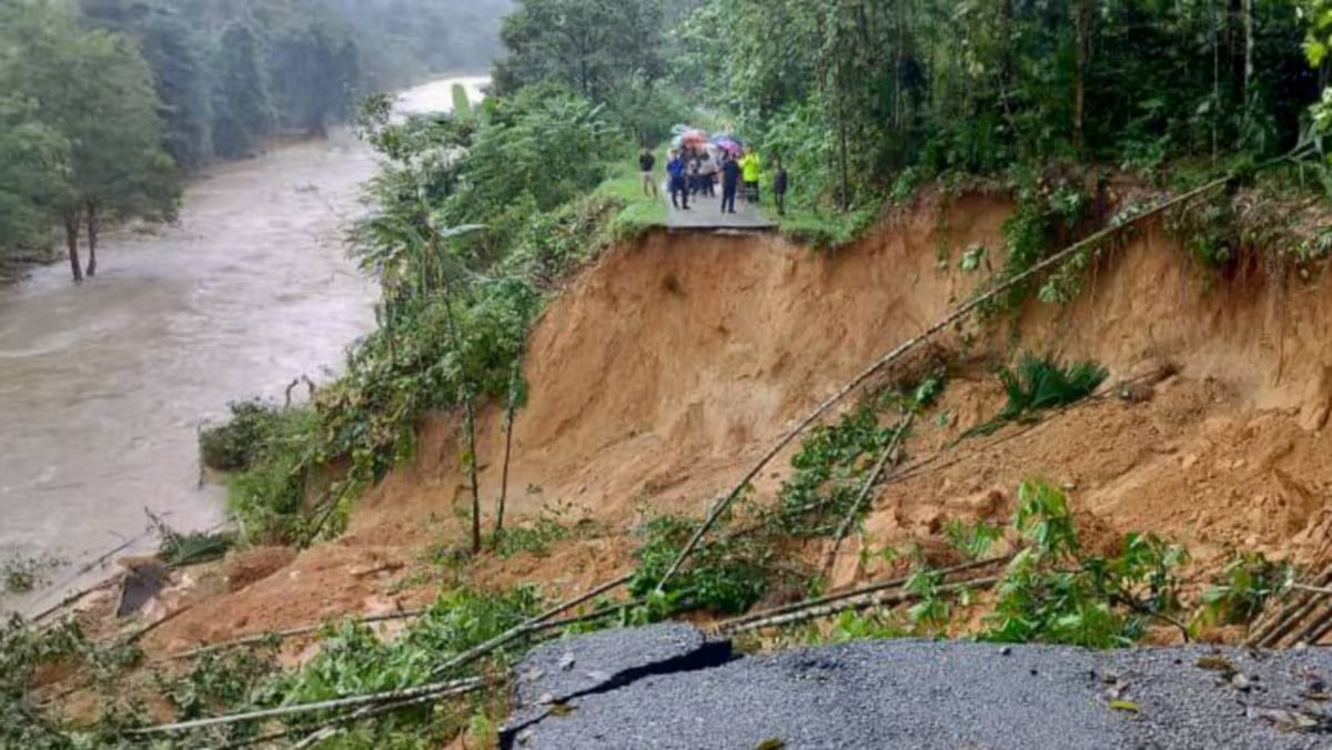 JALAN di Kampung Seberang Janggut runtuh akibat hujan lebat menyebabkan lebih 200 penduduk terputus hubungan. FOTO ihsan Bomba
