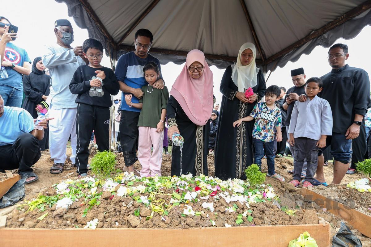 MOHD Roshdi (dua kiri) bersama anak-anaknya, Riyadh Haziq (kiri) dan Raisya Hannah (tiga kiri), ibu mertuanya, Siti Nooriah Hasan  (tengah) dan adik iparnya, Siti Norhazlinda Kamarudin (empat kanan) menabur dan menyiram air bunga mawar di pusara Siti Nor Hafiza selepas selamat dikebumikan di Tanah Perkuburan Raudhatul Sakinah, Taman Selasih. FOTO Aswadi Alias