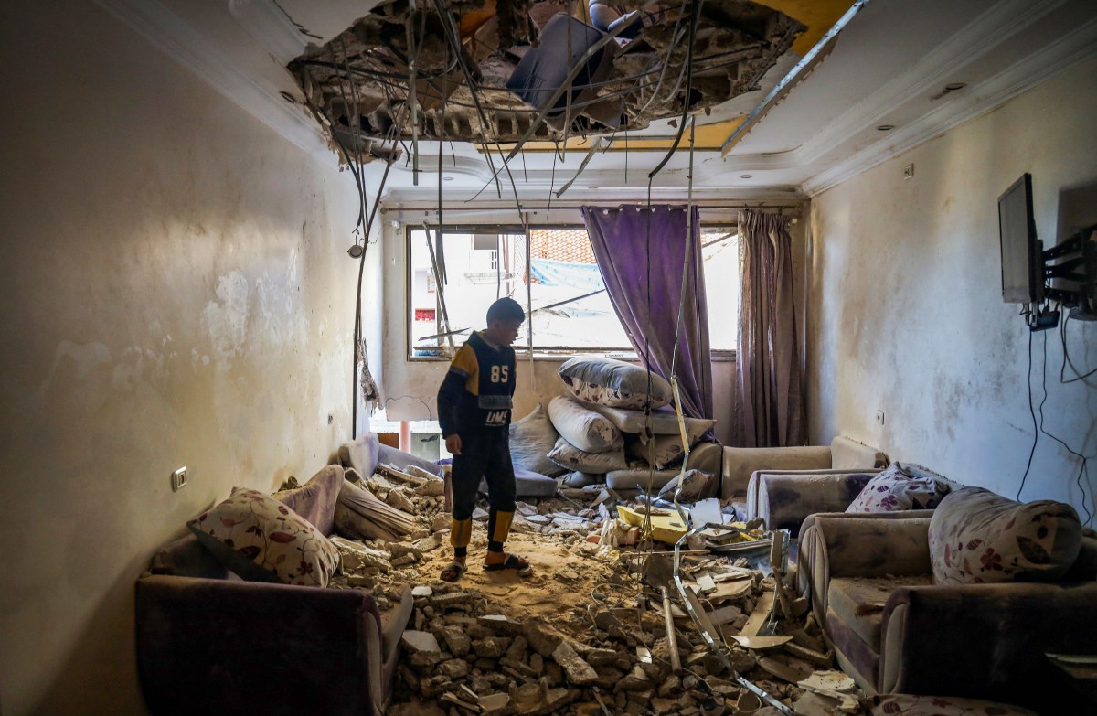KANAK-KANAK Palestin di bilik tamu bangunan yang rosak akibat pengeboman Israel di Rafah. FOTO AFP