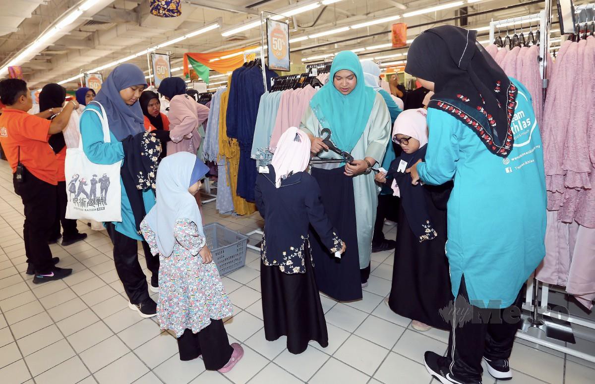 KANAK-KANAK memilih pakaian bagi persiapan menyambut Aidifitri anjuran AEON BiG, Coca-cola Bottlers Malaysia dan sokongan Yayasan Ikhlas di AEON BiG, Subang Jaya. FOTO Amirudin Sahib