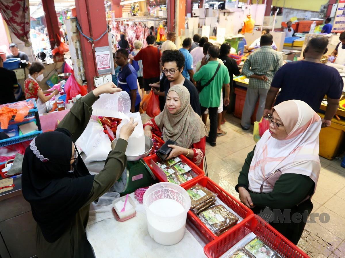 Peniaga santan Zainon Mustafar, tidak menang tangan melayan orang awam  membeli barang keperluan di Pasar Besar Jalan Othman, Kuala Lumpur. FOTO NSTP/SAIFULLIZAN TAMADI