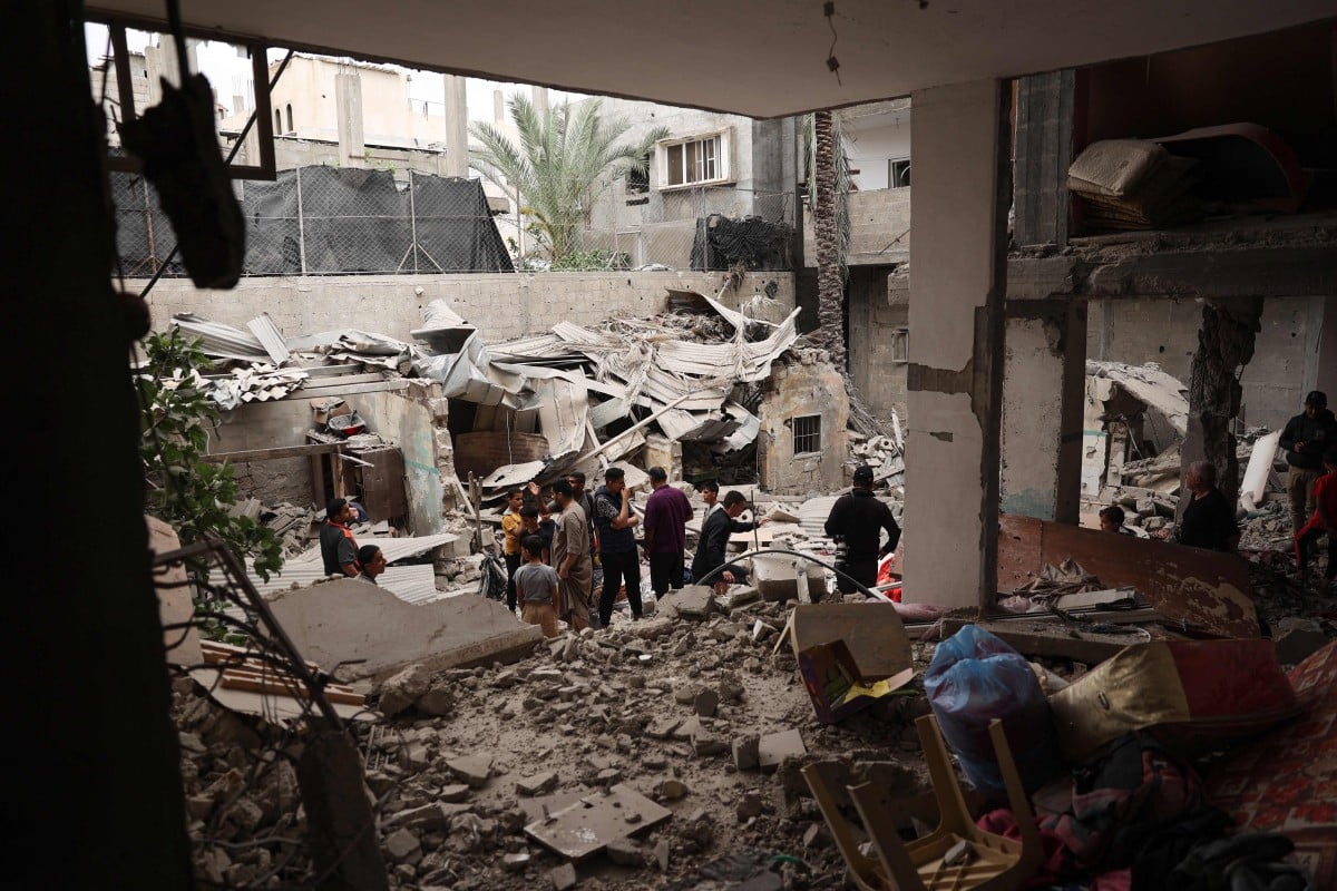 PENDUDUK memeriksa kerosakan rumah yang dibom tentera Israel di Rafah. FOTO AFP