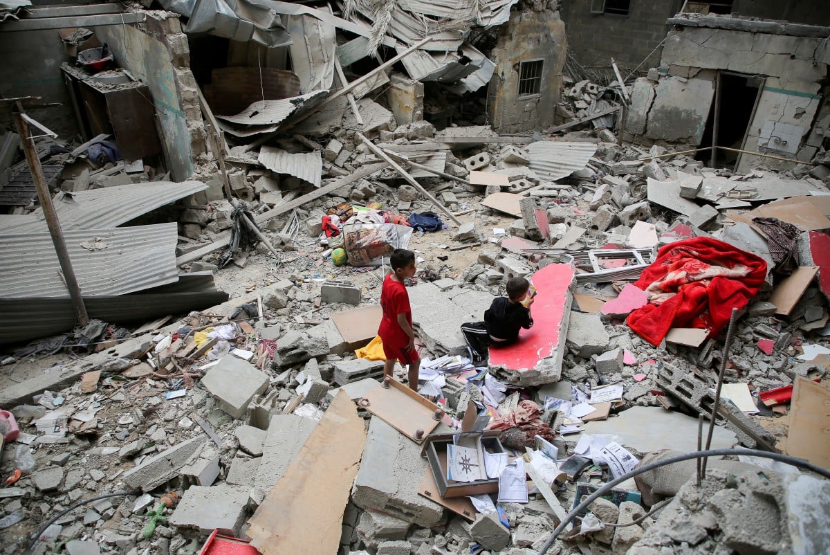 KANAK-KANAK Palestin memeriksa rumah yang dibom tentera Israel di Rafah pada 27 April 2024. FOTO Reuters