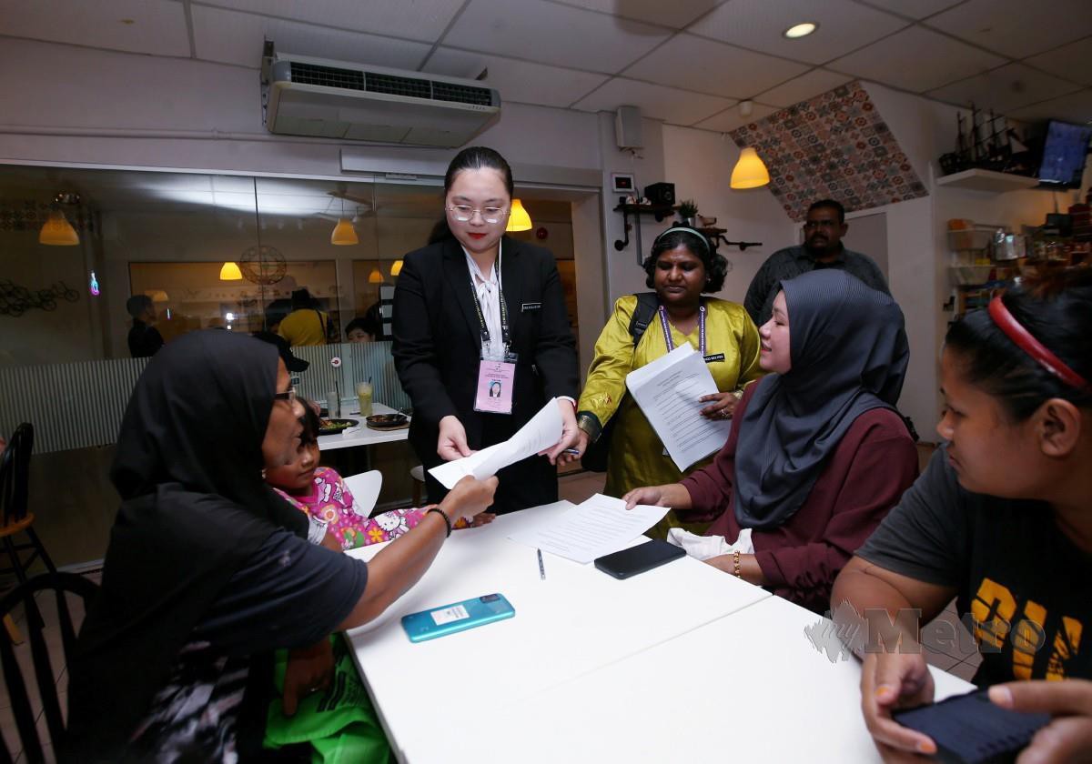 KE Xin (tengah) menerangkan manifestonya kepada orang ramai di pekan Kuala Kubu Bharu. FOTO Eizairi Shamsudin