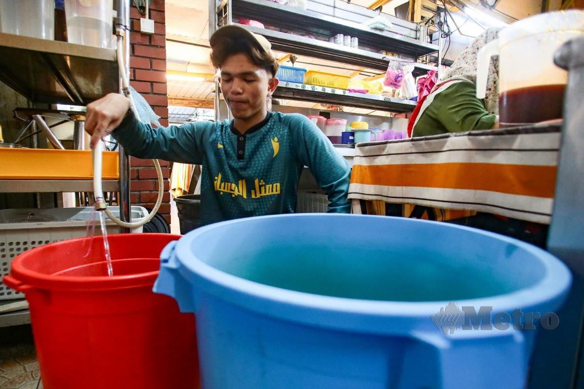 PEKERJA restoran nasi ayam menyimpan air dalam tong air sebagai persediaan bagi gangguan bekalan air berjadual di beberapa kawasan di Daerah Petaling, Klang, Shah Alam, Gombak dan Kuala Lumpur. FOTO Genes Gulitah