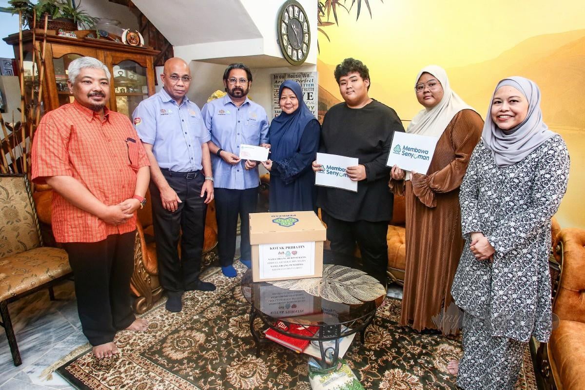 SUBAHAN (tiga kiri) bersama Pengarah PERKESO Selangor, Ismail Abi Hashim (dua kiri) memberikan faedah Perkeso kepada Khairana. FOTO Genes Gulitah